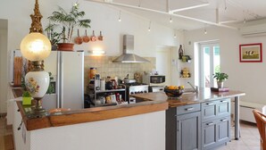 Una cocina con una isla central, estufa, microondas y diversos utensilios.
