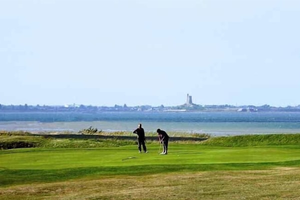 Golf de Fontenay sur mer en bord de plage et vue sur le fort de la Hougue