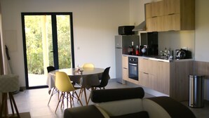 Una cocina moderna con comedor, sofá y vistas a través de un ventanal.