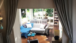 Un salon confortable avec un canapé, une petite table sur laquelle se trouve une théière et un fauteuil en cuir.