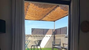 A hotel room with a large window, a bed, a chair, and a small balcony with a slide. - ST REMY DE PROVENCE APARTMENTS AND LOFTS (Saint-Rémy-De-Provence)
