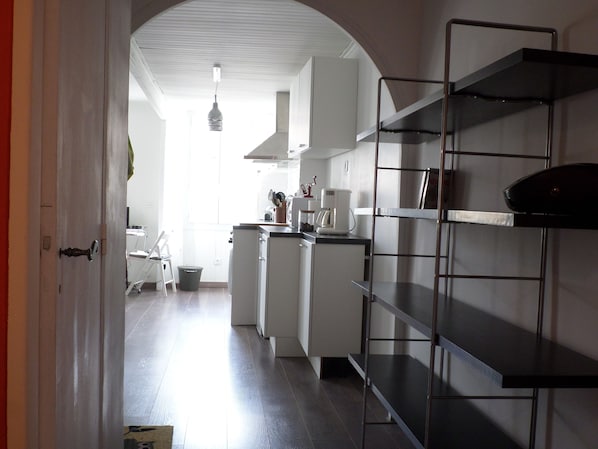 A narrow kitchen with white cabinets, a coffee maker, and a metal shelf unit. - T2, Panier district, Old port, MuCEM (Marseille)