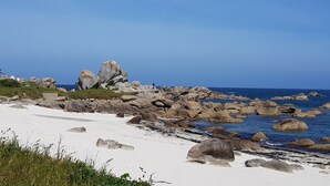 A beach with a lighthouse, large rocks, and clear blue water. - HOUSE WITH SUPERB SEA VIEW IN ROSCOFF - 4 STARS (Roscoff)
