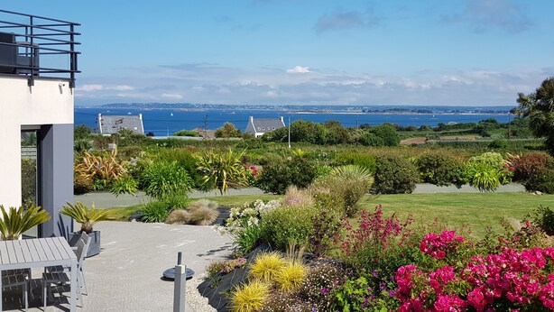 A modern building with a balcony overlooking a landscaped garden and a coastal view. - HOUSE WITH SUPERB SEA VIEW IN ROSCOFF - 4 STARS (Roscoff)