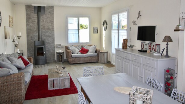 Uma sala de estar aconchegante com lareira, um sofá, uma mesa de jantar e uma TV.