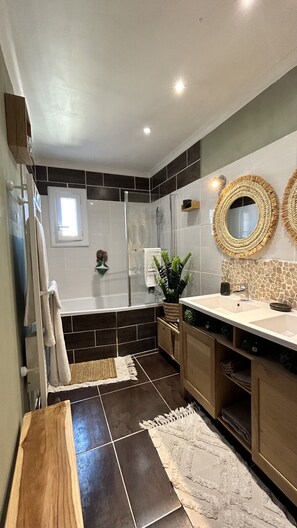 Bañera con ducha, toallas, papel higiénico