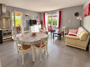 A modern living space with a dining area, kitchen, and seating area.