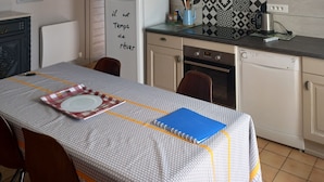 A modern kitchen with a white refrigerator, a coffee machine, and a patterned backsplash. - Beautiful house typical from Oleron (Saint-Pierre-D'oléron)