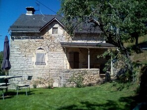 A stone house with a sloped roof and a small porch. - Restored farmhouse in its original style. Accommodation in Caussignac. (ST ENIMIE)
