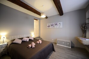 Ein Schlafzimmer mit einem großen Bett, einem Nachttisch, einer Kommode und einem an der Wand befestigten Kunstwerk.