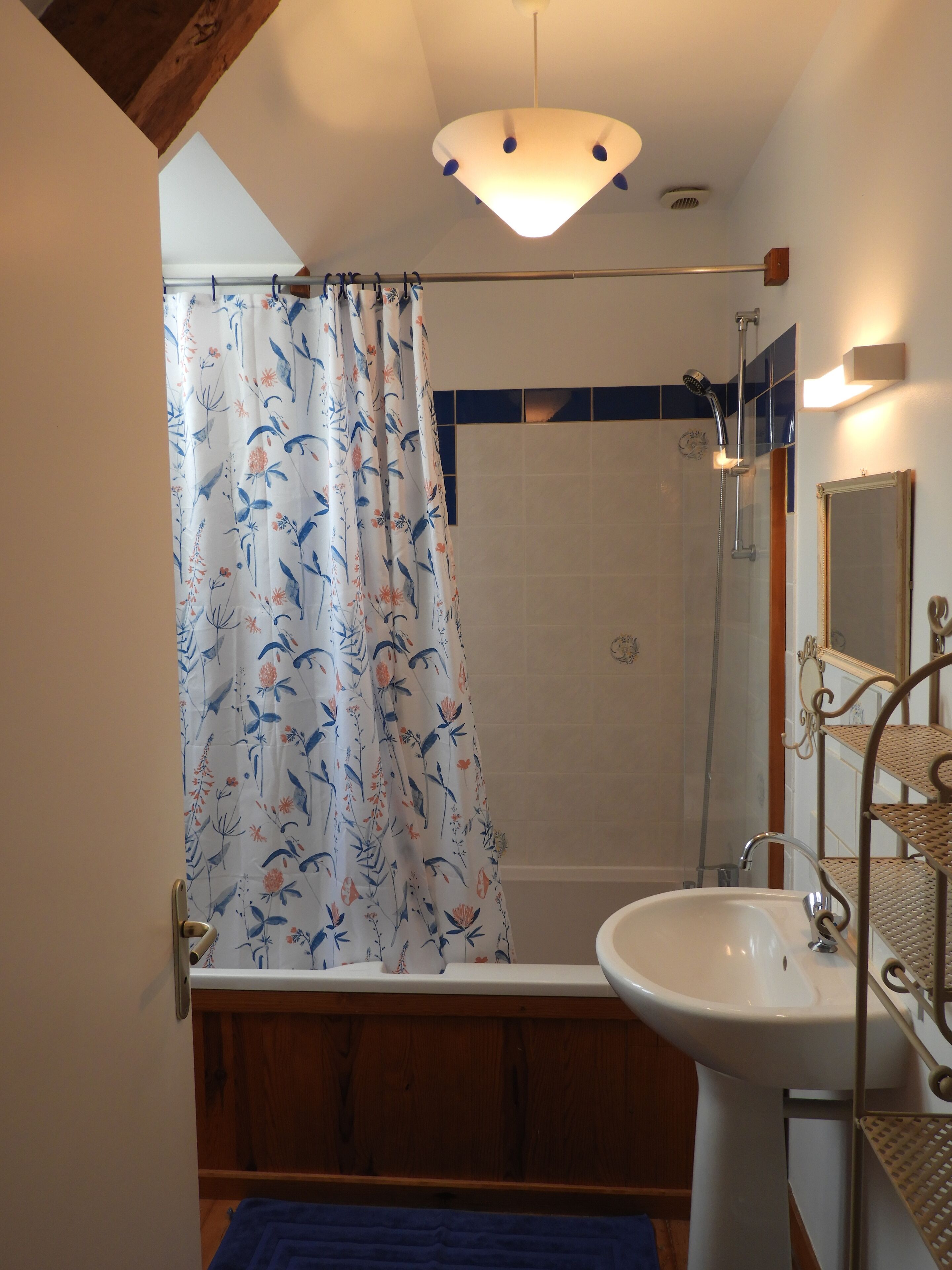 Ein Badezimmer mit Dusche, Waschbecken und Spiegel.