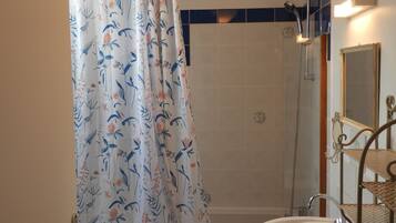 Ein Badezimmer mit Dusche, Waschbecken und Spiegel.