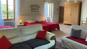 A room with two beds, a wooden wardrobe, a sofa, and a chair. - Witihin the marais poitevin, house with character is an enjoyable place to stay (Damvix)