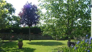 A well-maintained garden with a variety of plants and trees, a stone wall, and a grassy lawn. - House on the outskirts of Saint Malo and on the banks of the Rance, 2 bedrooms, 2 bathrooms  (Saint-Jouan-Des-Guérets)
