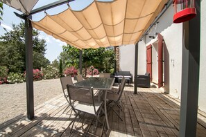An outdoor patio with a glass table and chairs, a beige canopy, and a red lantern. - Promo: Villa 4 * comfort 9 pers., Quiet private pool, Provence 800m villag (Flayosc)