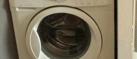 A white Brandt front-loading washing machine with a control panel featuring various settings and buttons.