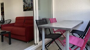 Una sala de estar moderna con un sofá rojo, una mesa de comedor y sillas.