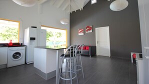 A modern kitchen with a central island, bar stools, a washing machine, and a refrigerator. - Villa Bel Plaisi - Tropical villa with private pool - 7 pers - Le Moule (Le Moule)