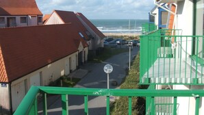 Un área residencial costera con casas, una calle y vista al océano.