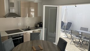 Eine moderne Küche mit Essbereich, inklusive Tisch und Stühlen sowie Blick ins Freie.