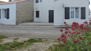 Ein zweistöckiges Gebäude mit einer Stein-Fassade und einem weißen oberen Bereich.