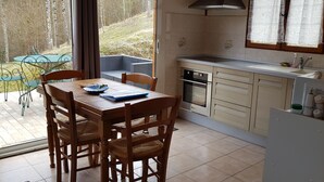 A kitchen with a dining table and chairs, a built-in oven, and a sink. - The cottage Baragnou lantern Nalzen (Nalzen)