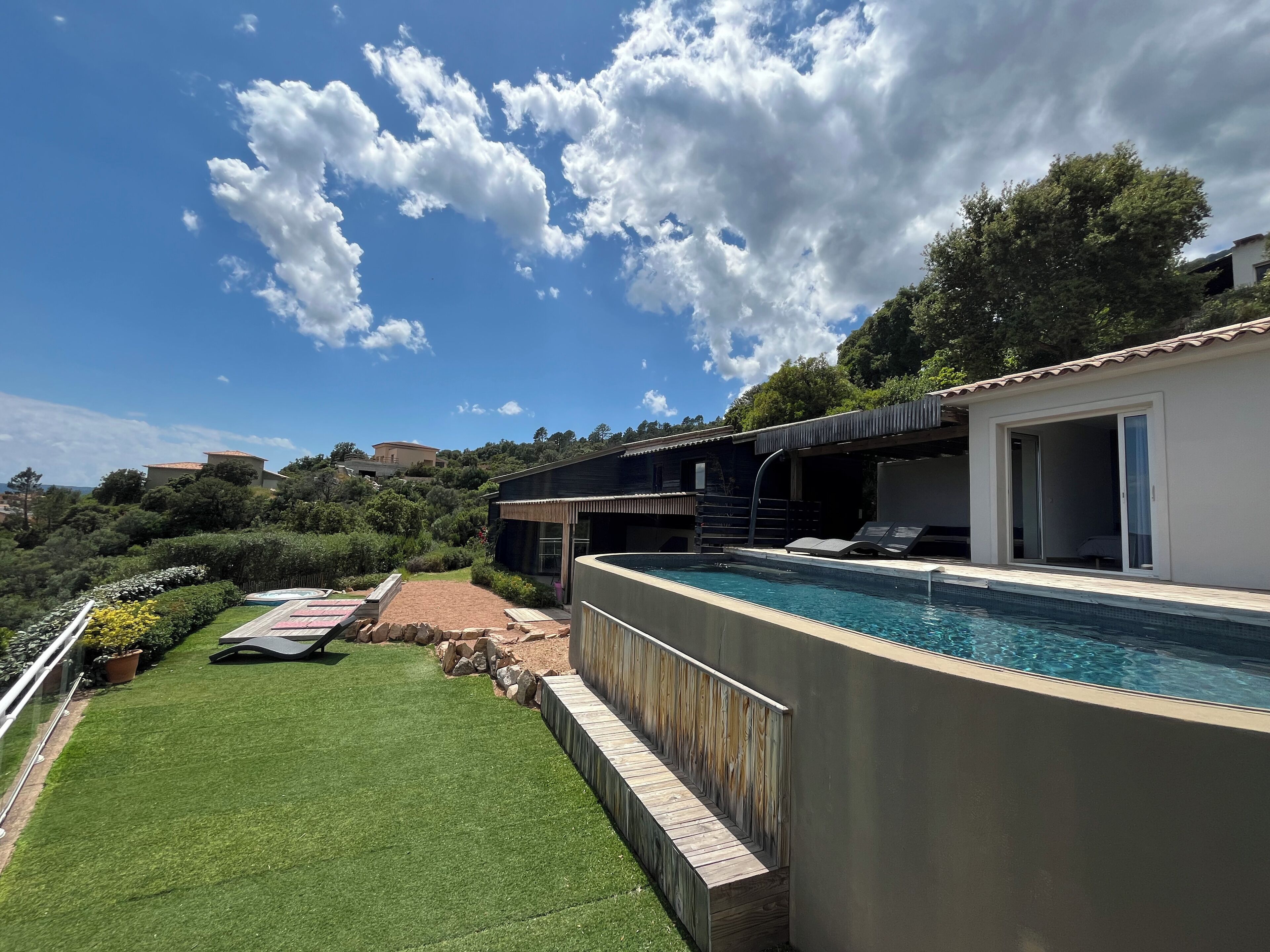 Un espace piscine extérieur moderne offrant une vue dégagée sur le ciel et la végétation environnante.