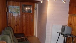 A cozy living room with a green armchair, a wooden coffee table, and a television on a stand. - Have a breath in our mountains. (La Bresse)