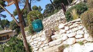 A rustic stone wall with a thatched roof structure. - Charming 2-person gite with pool between Luberon and Alpilles (Cavaillon)