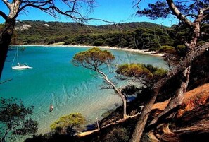 Un paisaje costero con aguas turquesas cristalinas, un bote y una playa.