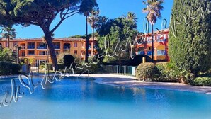 A swimming pool with a building in the background. - Hyères on the Peninsula Giens, Beach and swimming pool facing Porquerolles *** ! (Hyères)