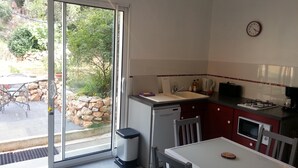 Cocina compacta con fregadero, cocina y comedor.
