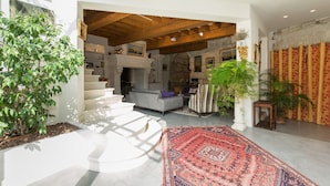 A spacious living area with a staircase, a fireplace, and a large rug. - Quiet home in the heart of the Alpilles with private pool (Eyragues)