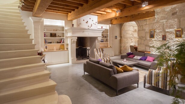 A spacious living area with a fireplace, a staircase, and a stone wall. - Quiet home in the heart of the Alpilles with private pool (Eyragues)