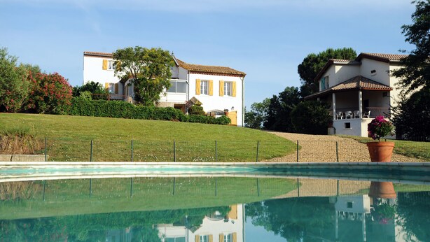 A swimming pool with a clear reflection of a house and surrounding greenery. - Hameau-Montplaisir, Béziers (Béziers)