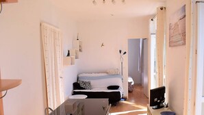 A compact living space with a kitchenette, a dining area, and a bed. - Bright apartment for 2, Trébeurden center, near beach, pets allowed (Trébeurden)