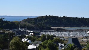 A coastal town with a marina, residential buildings, and a forested hill. - Bright apartment for 2, Trébeurden center, near beach, pets allowed (Trébeurden)