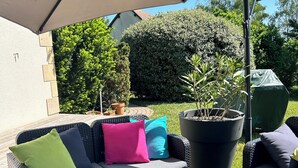 An outdoor patio with a wicker sofa, a table with food and drinks, and a large umbrella. - House with pool in the heart of the Castles of the Loire (Cour-Cheverny)