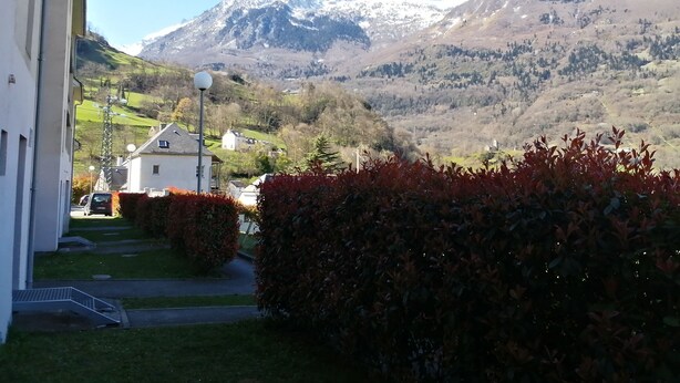 Ein Wohngebiet mit einem Haus, einer Straße und einem Bergpanorama im Hintergrund.
