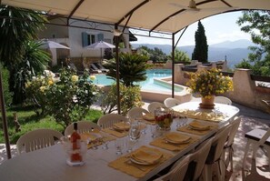 A dining table set for six with a view of a pool and mountains in the background. - Very beautiful Provencal house sleeps 6/12 in a quiet area in Le Beausset, Var (Le Beausset)