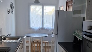 Una cocina con mesa de comedor, refrigerador y microondas.