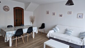 Un comedor con una mesa y sillas, un sofá y una mesa blanca.