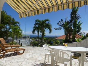Outdoor dining - Studio South East, large terrace facing the sea in tropical garden. (capesterre belle eau)