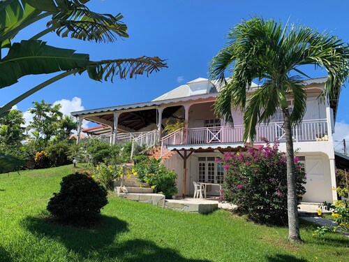 Studio Südost, große Terrasse mit Meerblick in tropischem Garten.