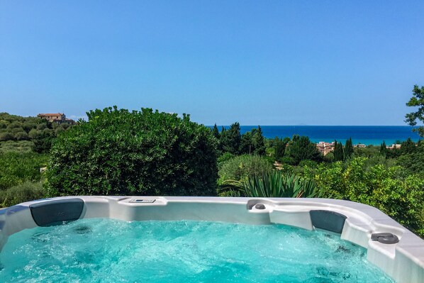 A hot tub with a clear view of the sea and a building in the background. - Villa with swimming pool, jacuzzi and tennis, in front of the Aeolian Islands  (Messina)