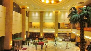 A spacious lobby with a high ceiling, multiple levels, and a central open area.