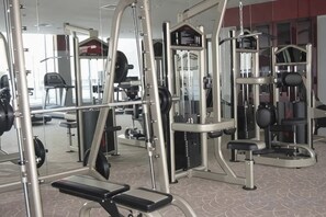 Un gimnasio con diversos equipos de ejercicio, incluyendo máquinas de pesas y pesas libres.