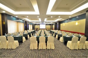 A conference room with rows of tables and chairs, equipped with water bottles and nameplates. - Perfect International Hotel (Qidong)