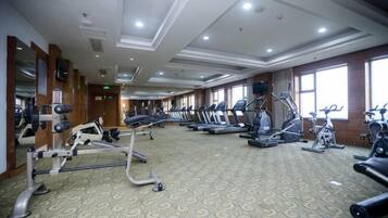 A gym with treadmills, elliptical machines, and weight equipment.