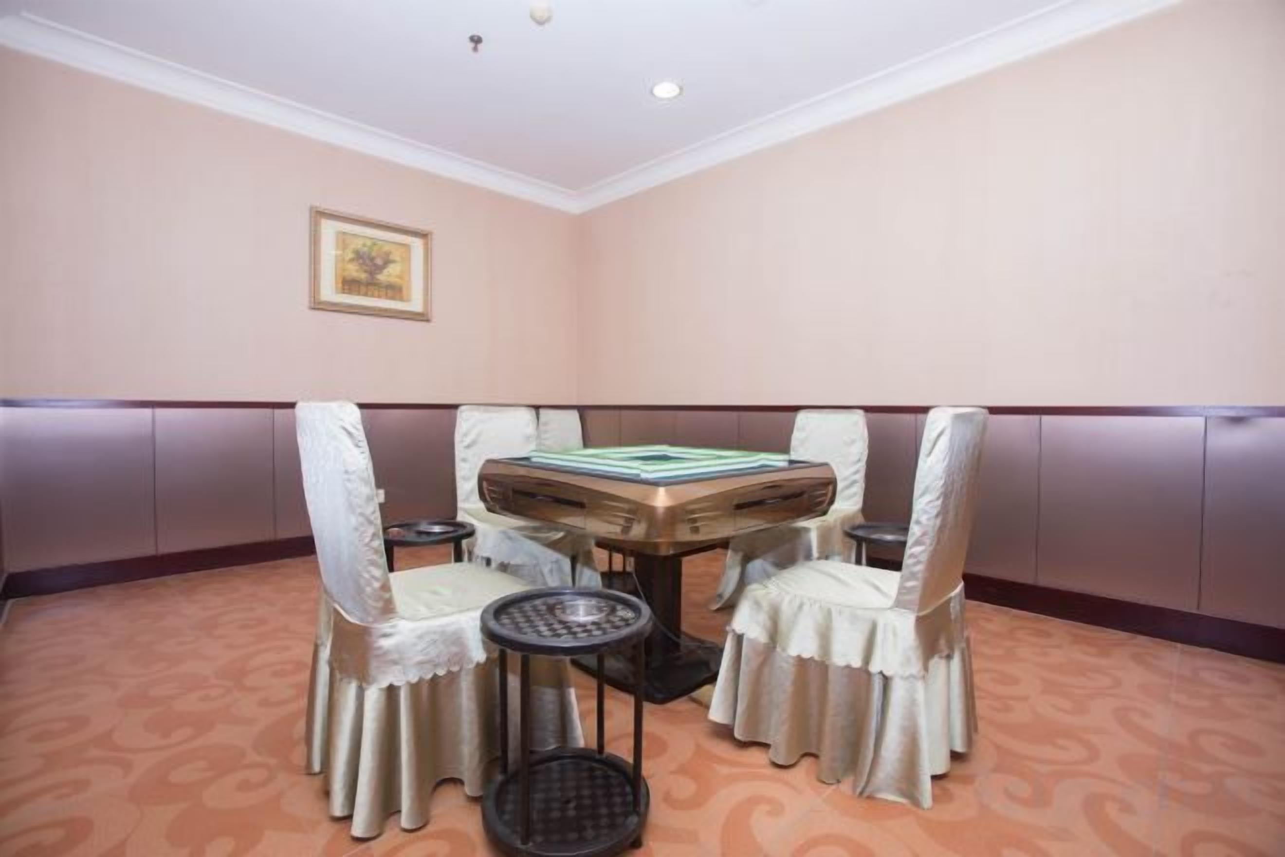 Una sala de conferencias con una mesa redonda, cuatro sillas y una mesita auxiliar.